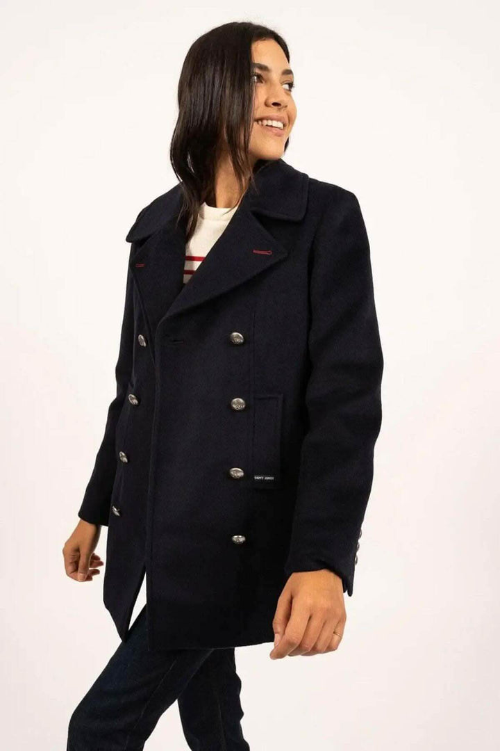 Manteau Briac en marine, style caban, avec double boutonnage et col cranté, porté par une femme souriante.