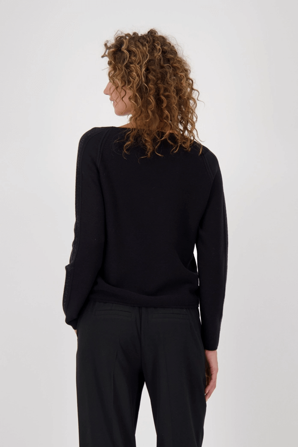 Femme portant un chandail avec des accents décoratifs vu de dos