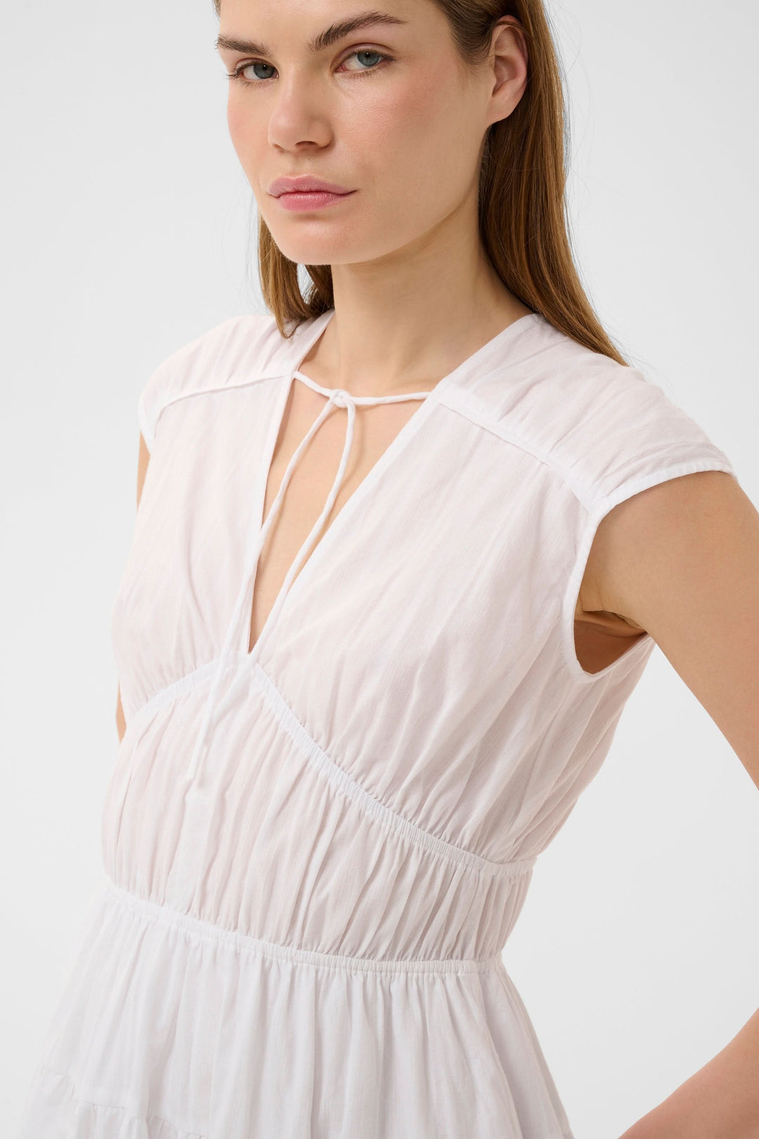 Pink, short, flowing dress with gathered details and a tied neckline