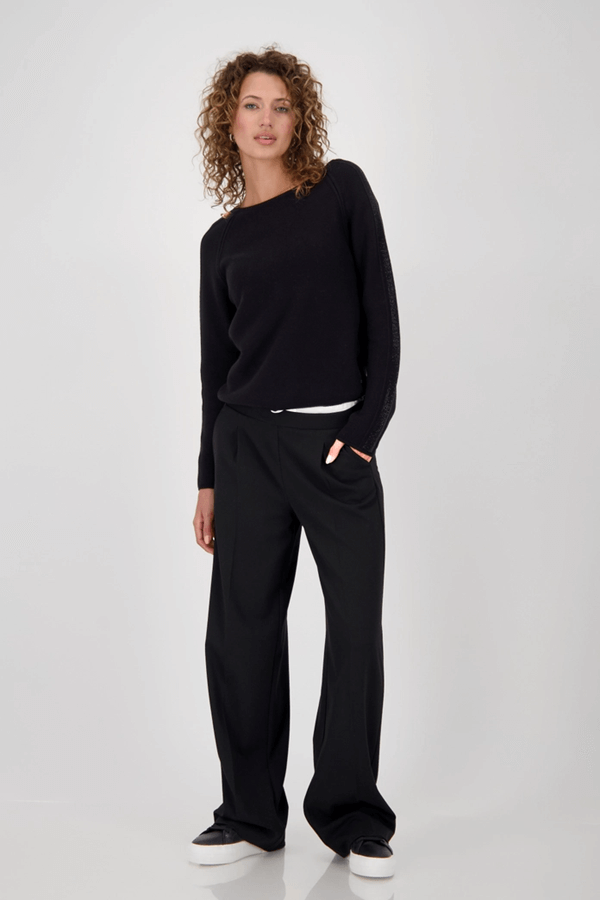 Femme portant un chandail avec des accents décoratifs, coupe droite, manches longues, parfait pour tenues de bureau et décontractées.