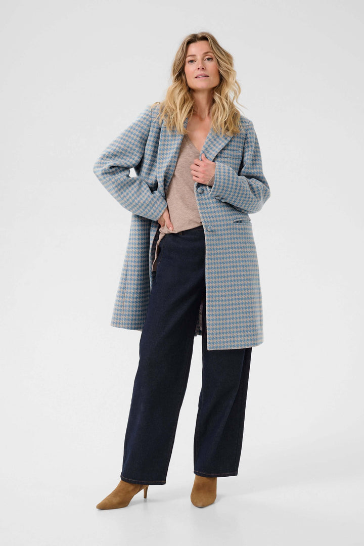 Femme portant le Manteau Westie à motif pied-de-poule et coupe droite, élégant et texturé pour un look chic et polyvalent.