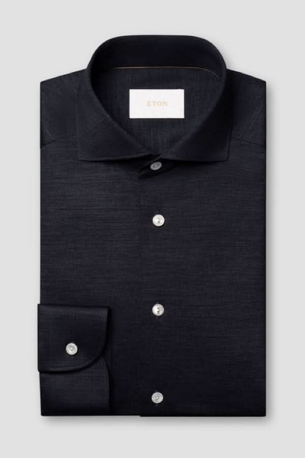 Chemise en jersey de laine mérinos noire avec col italien et boutons nacrés, élégante et confortable.