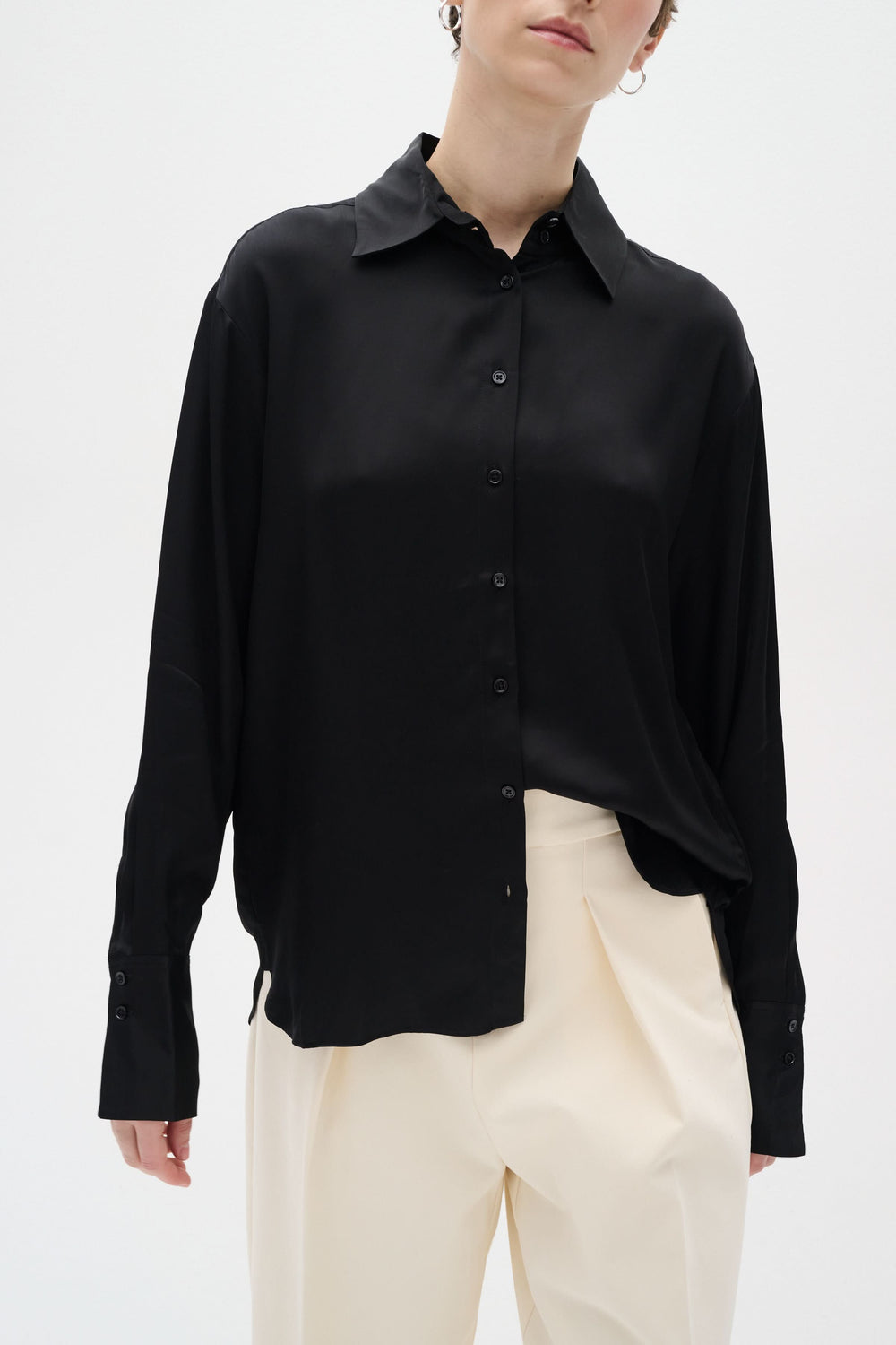 Chemise Pauline satinée noire avec coupe ample et boutons, parfaite pour un style chic décontracté.
