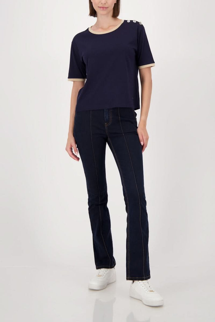 T-shirt à boutons décoratifs sur l’épaule porté par une femme, style décontracté avec bordures contrastantes et confort optimal.