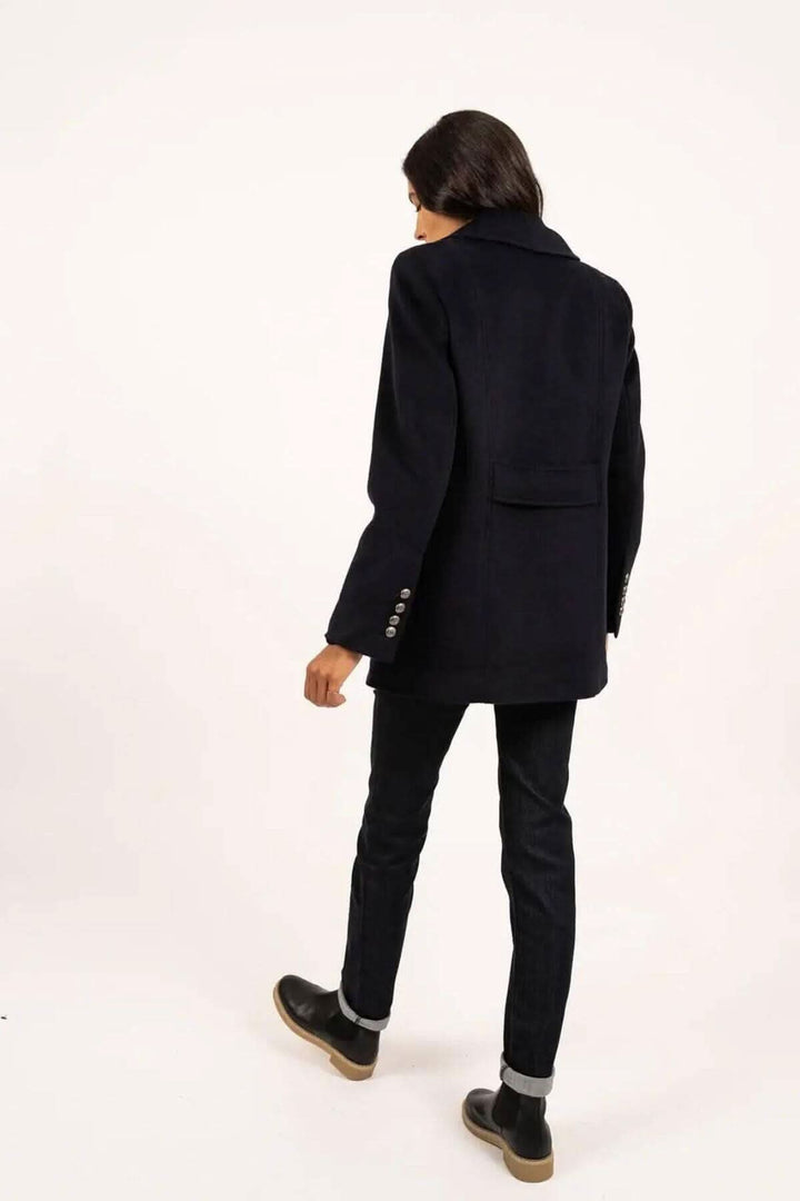 Manteau Briac noir, vue arrière, col cranté, porté avec un jean et des bottines pour un style élégant.