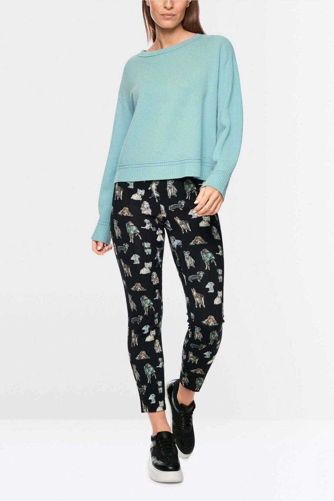 Woman wearing a blue long-sleeve sweater and printed pants, perfect for a casual stylish look.