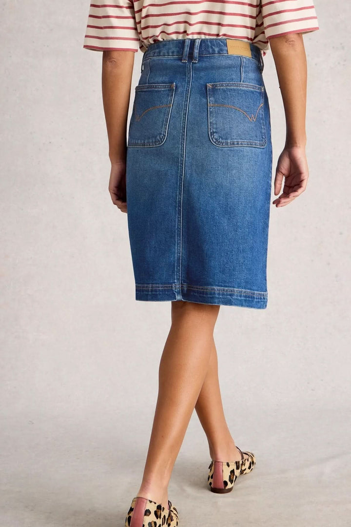 Vue arrière de Jupe Tia en denim classique avec coupe droite et taille haute, portée avec un t-shirt rayé et des chaussures imprimé léopard.