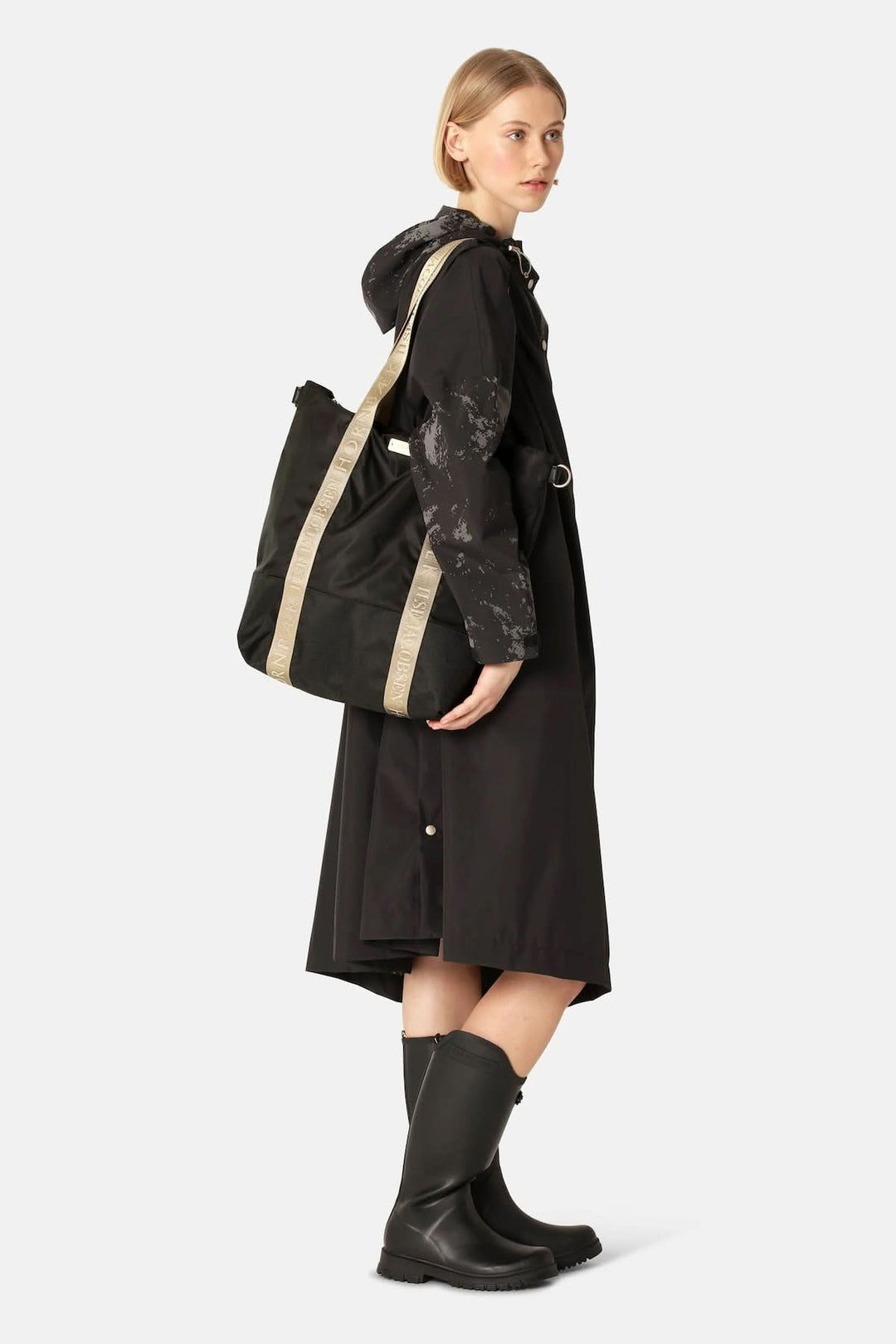 Femme portant un Sac Cabas à main en nylon avec bandoulière ajustable, fond résistant, sangles logotées, idéal pour le style et la fonctionnalité.