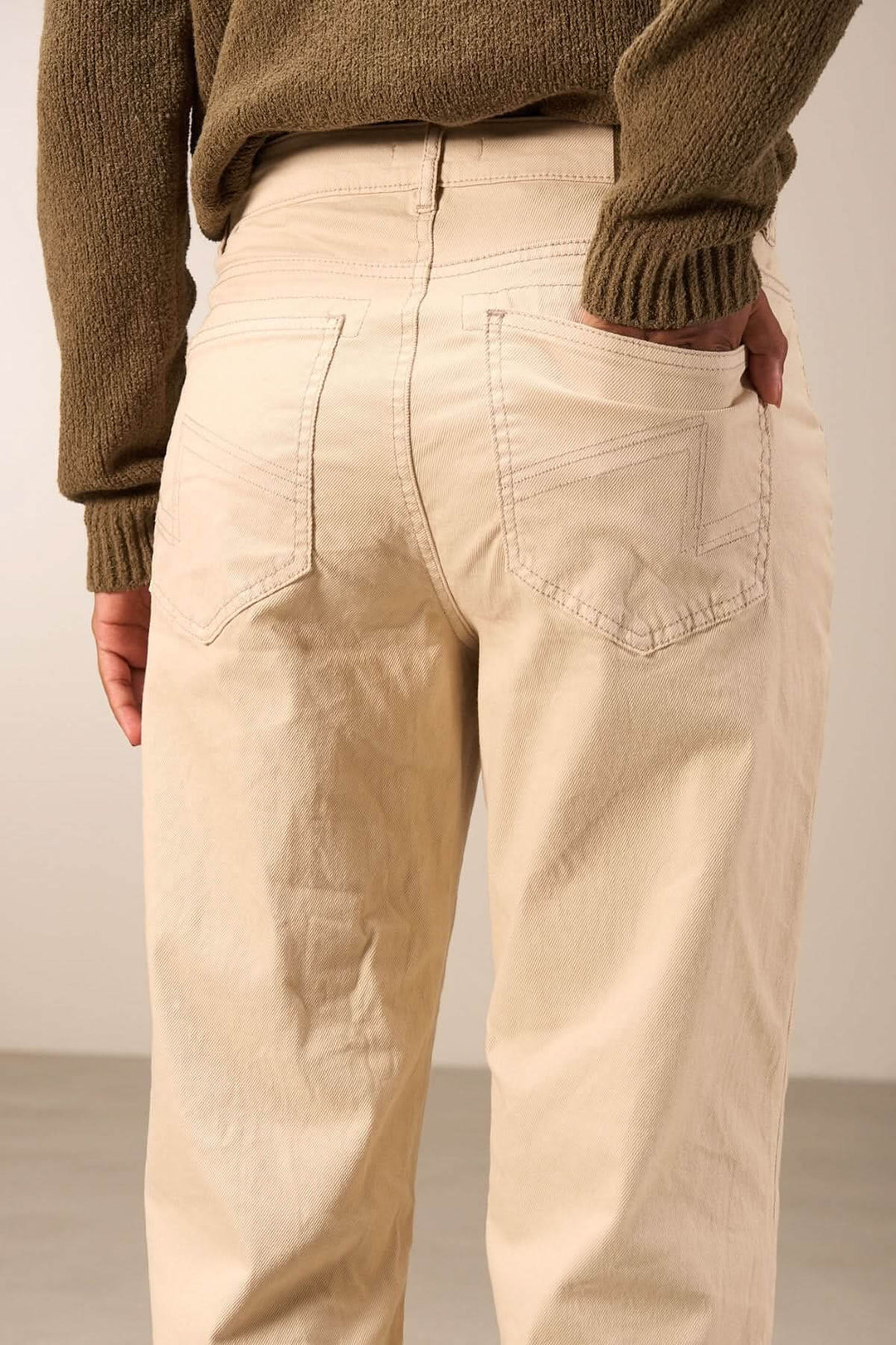 Pantalon droit beige avec poches arrière, coupe décontractée et taille mi-haute, parfait pour un look casual-chic.