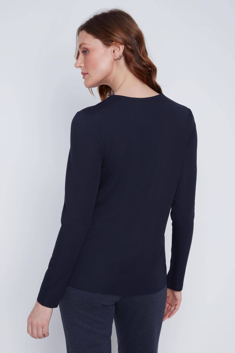 Femme portant un chandail à manches longues noir, vue arrière, encolure en V zippée, style moderne et décontracté.