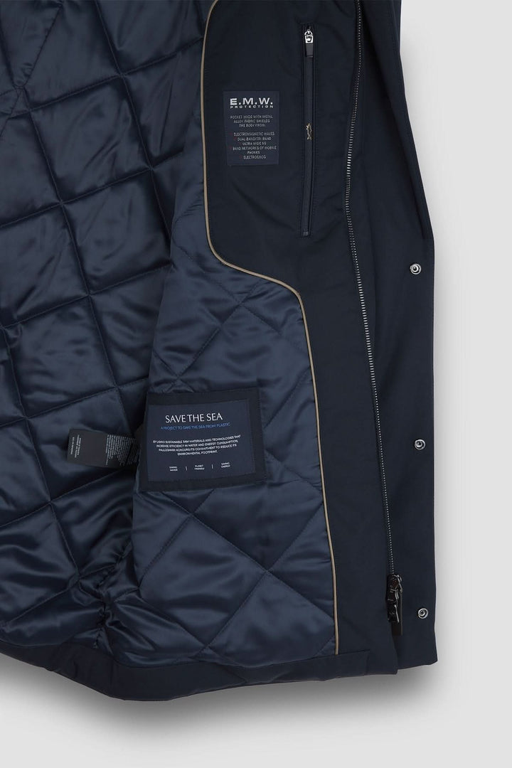 Intérieur d'un manteau matelassé, illustrant le doublage technique et les étiquettes de durabilité.