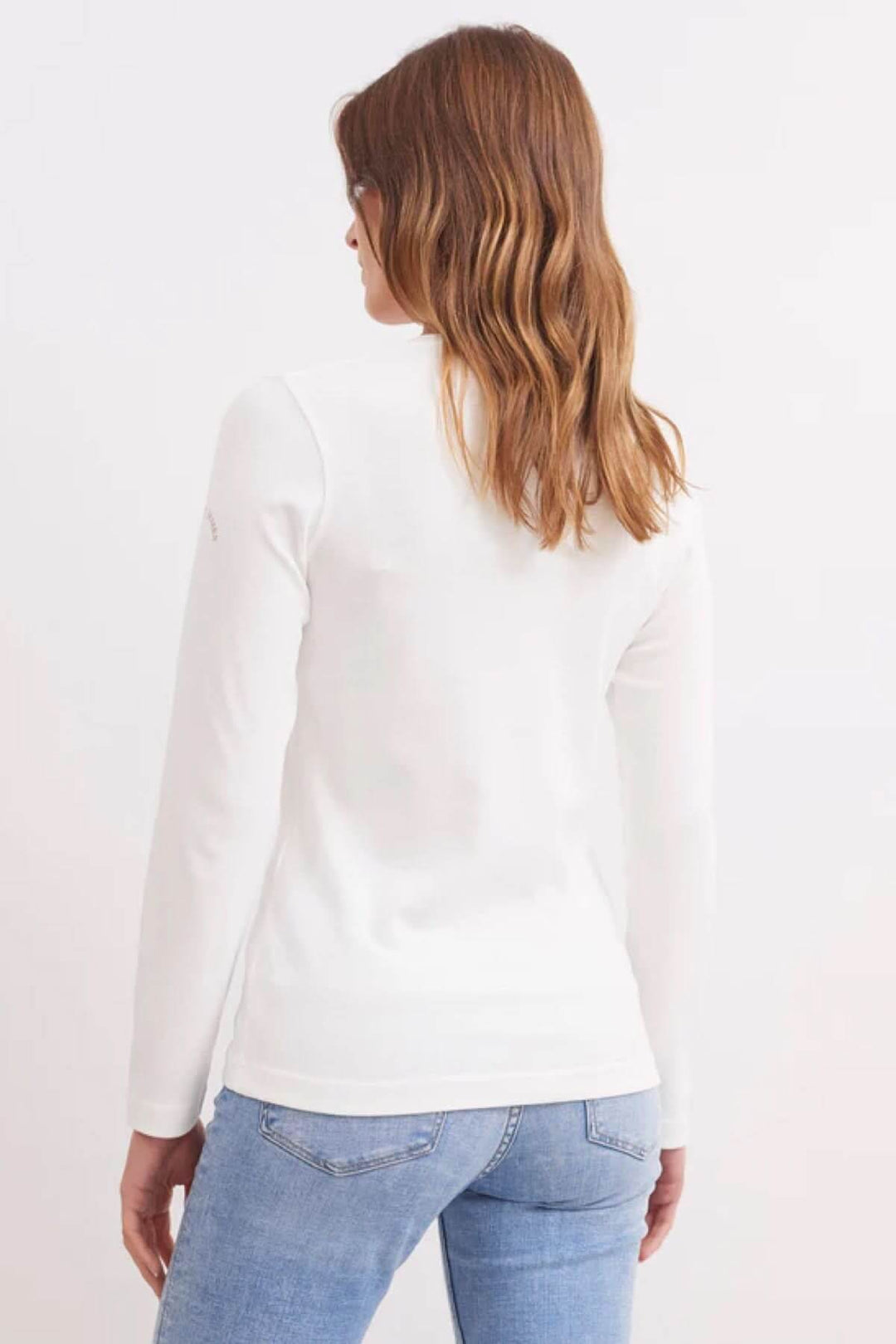 Chandail à manches longues blanc avec une coupe droite, porté par une femme de dos, sur fond neutre.