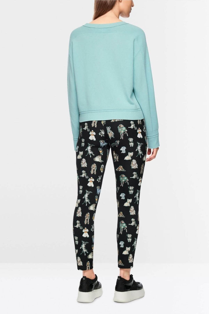 Vue arrière d'un chandail manches longues bleu avec design minimaliste et coupe ample, porté avec un legging imprimé.