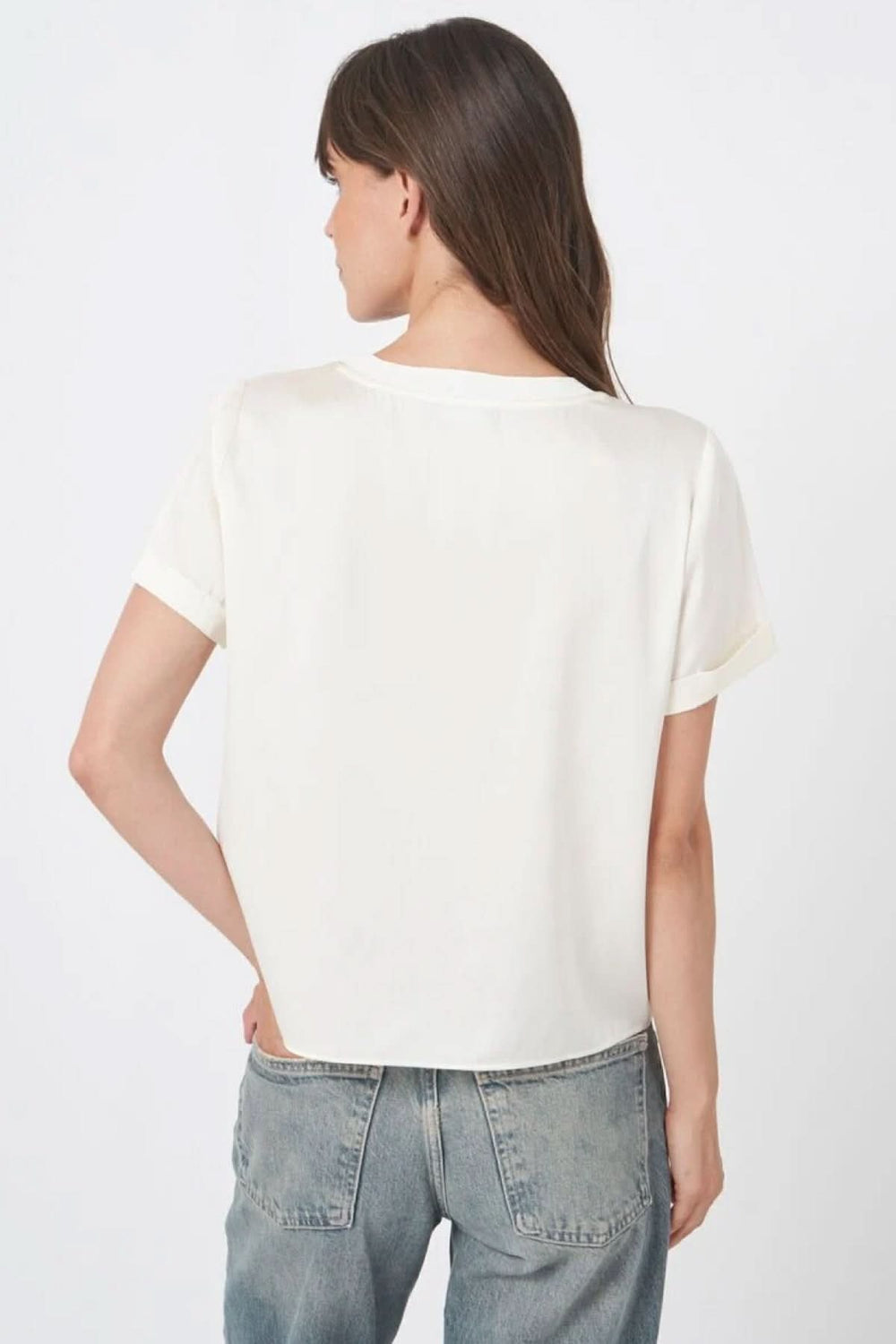 Vue arrière d'une blouse en soie blanche à manches courtes et encolure ronde, portée par une femme, parfait pour un look chic et décontracté.