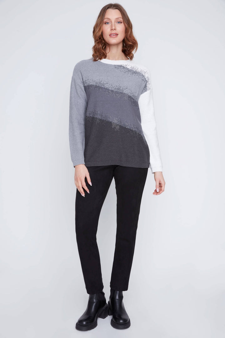 Chandail à dégradés gris avec détails scintillants, coupe droite et confortable, porté avec un pantalon noir.