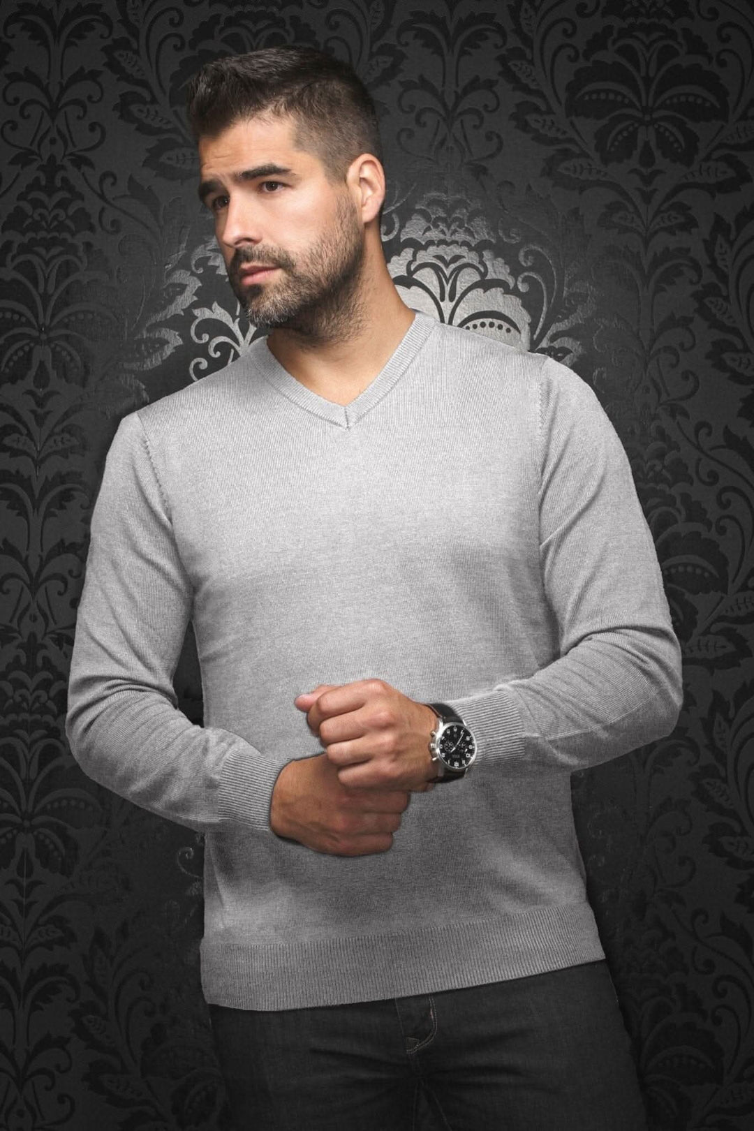 Homme portant un chandail col en V en mérinos gris pâle, ajustement confortable avec un fond élégant.