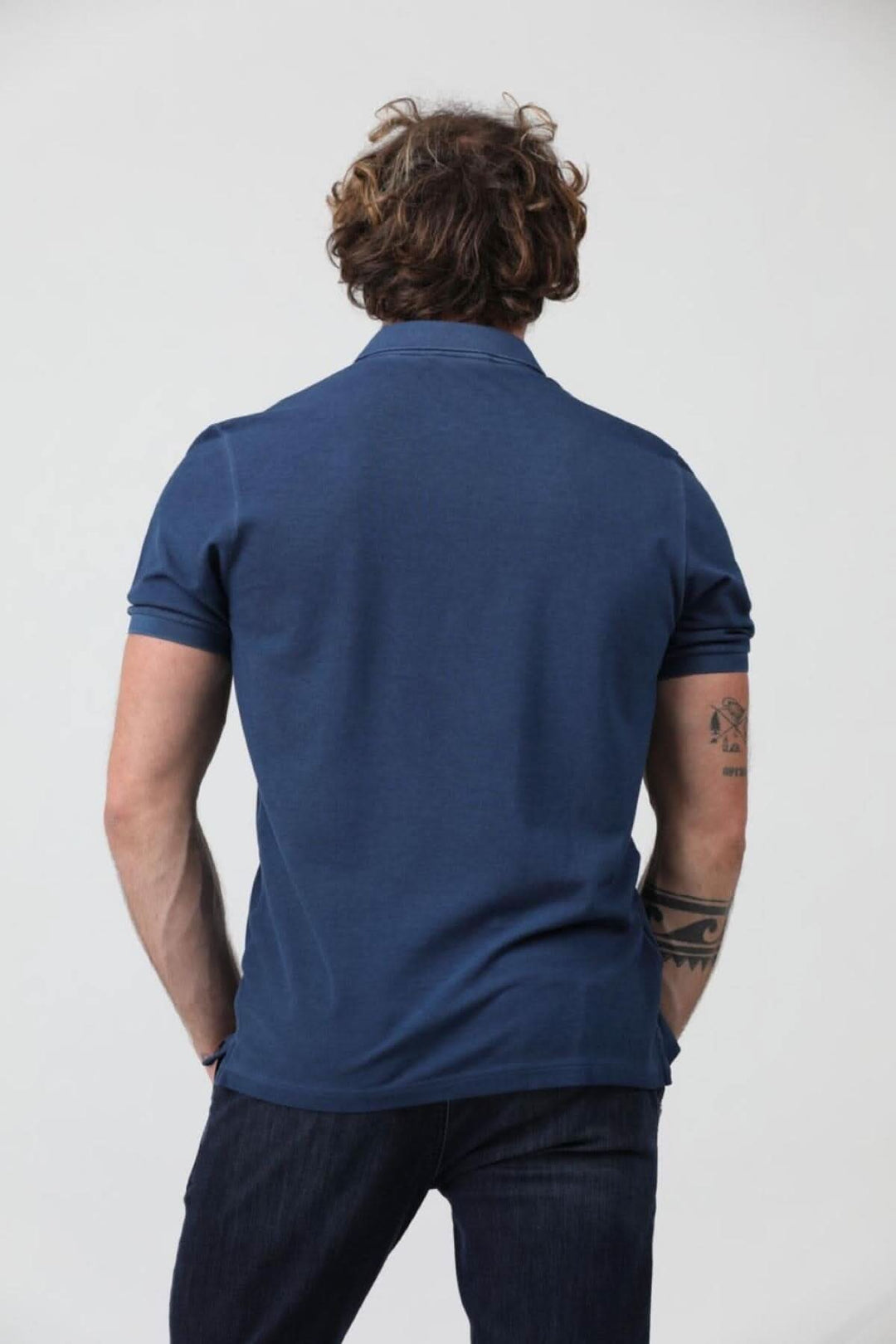 Homme portant un polo à manches courtes en jersey de coton piqué, vue arrière, coloris bleu.