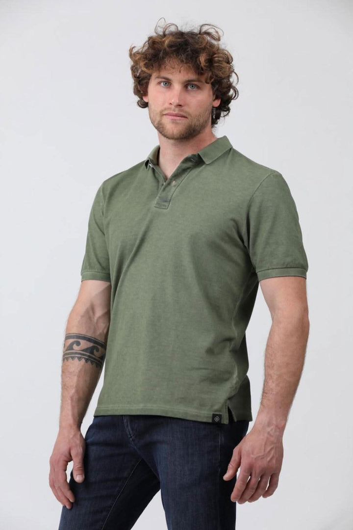 Homme portant un polo à manches courtes en jersey de coton piqué, couleur olive, associé à un jean.