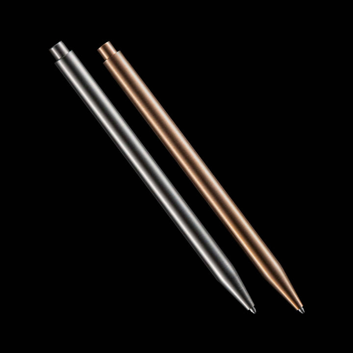 Deux stylos à carburant modernes en acier inoxydable et bronze sur fond noir.